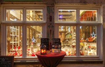 Shop window of a candy store with Christmas lighting at dusk