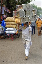 Man carrying cans on his head