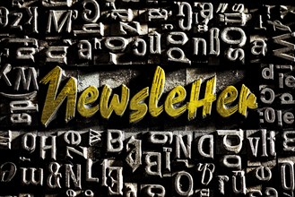 Old lead letters with golden writing show the word Newsletter