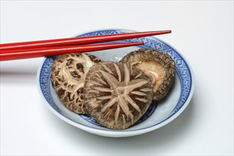 Dried shiitake mushrooms in bowls and chopsticks