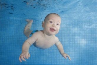 Little boy swim underwater in the swimming pool