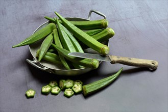 Okras in bowl and kitchen knife