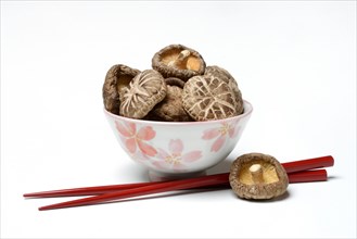 Dried shiitake mushrooms in bowl and chopsticks