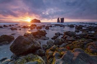 Sunset on a stony coast with huge rocks in the Atlantic Ocean