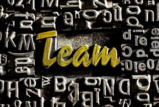 Old lead letters with golden writing show the word team