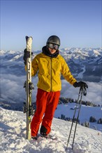 Skier standing at the ski slope holding ski