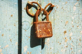 Old rusty door lock on weathered wooden door