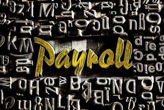 Old lead letters with golden writing show the word Payroll