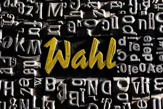 Old lead letters with golden writing show the word Wahl