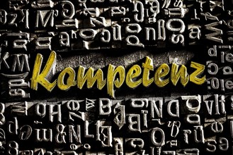 Old lead letters with golden writing show the word competence