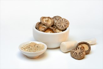 Dried shiitake mushrooms in a grating bowl and shiitake powder in small bowls