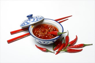 Crushed chilli peppers in oil in shell and red chopsticks