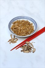 Dried mealworms in bowl and grills with chopsticks