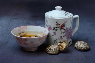 Shiitake tea in bowl and shiitake mushrooms