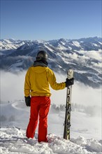 Skier standing at the ski slope holding ski
