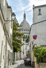 Small alley in Montmartre with view of the dome of the Basilica Sacre-Coeur