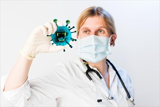 Doctor holding virus in her hand, symbol picture Coronavirus