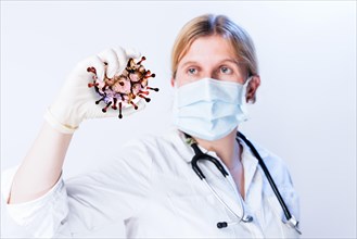 Doctor holding virus in her hand, symbol picture Coronavirus