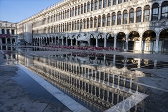Reflection of the procurations at Acqua alta on St. Mark's Square
