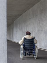Senior citizen in a wheelchair in an underpass