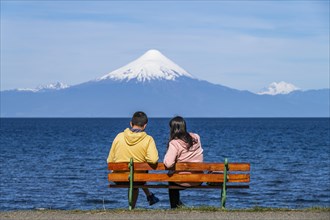 Couple sitting on the beach promenade at the lake Llanquihue