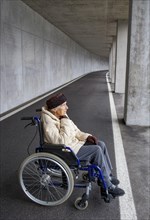 Senior citizen in a wheelchair in an underpass