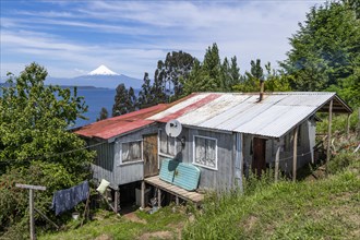 House made of corrugated iron with view to the Osorno volcano and the lake of Llanquihue