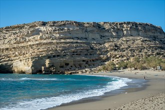 Sandy beach beach in front of the historic cave dwellings near Matala