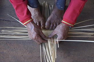 Man weaving a reed basket