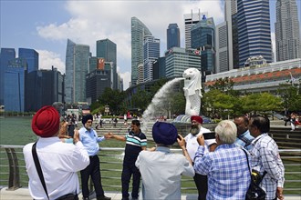Tourists taking pictures of themselves in front of the Merlion statue