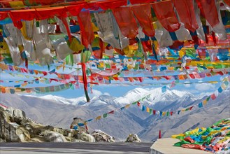 Pass road with Buddhist prayer flags at the Nachan La Pass (4500 m) above the Kyichu Valley