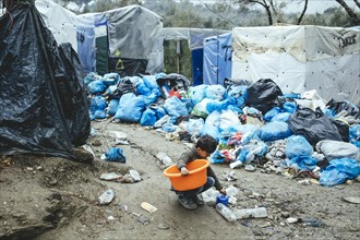 Child collects utensils from the garbage in the refugee camp in Moria