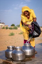 Woman collecting water from a community well