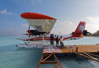 Passengers boarding seaplane De Havilland Canada DHC-6 Twin Otter of Maldivian Airlines