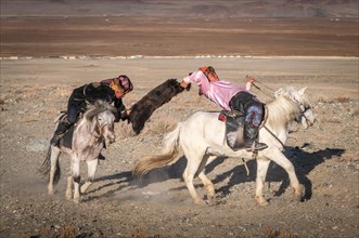 Two Kazakhs on horses at the traditional game Kokbar