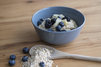 Porridge in bowl with blackberries and blueberries