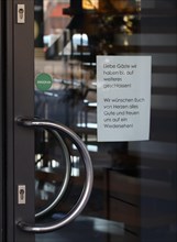 Note in shop window informs about closure due to Corona