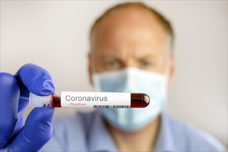 Man wearing protective mask and showing positive result of coronavirus test
