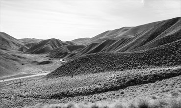 Black and white photo, barren mountain landscape with pass road