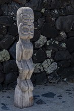 Guardian wooden tiki in front of big wall, Pu'uhonua O Honaunau National Historical Park
