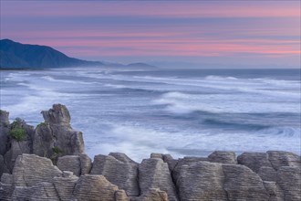 Rock formations of the Pancake Rocks in front of the ocean waves in the evening light, Paparoa National Park