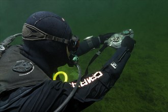 Divers in dry suits orientate themselves with compass in waters with poor visibility, Echinger Weiher