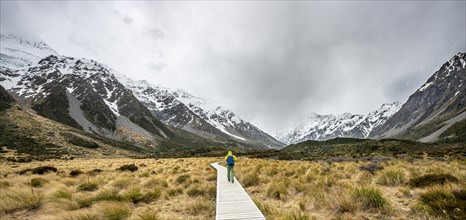 Hikers on plank, hiking trail in Hooker Valley with Mount Cook