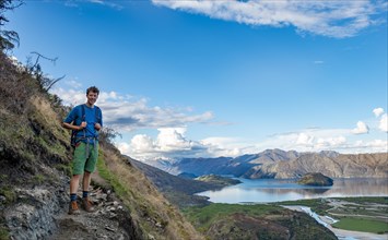 Hiker on the hiking trail to Rocky Peak, views of Wanaka Lake and mountains