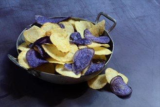 Different coloured potato chips in skin, food photography