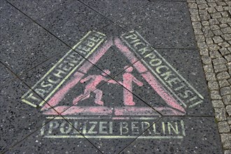 Sprayed stencil, police warning against pickpockets in German and English