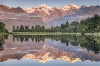 Snowy mountain peaks of Mount Cook and Mount Tasman reflected in Lake Matheson in the evening light, Westland National Park