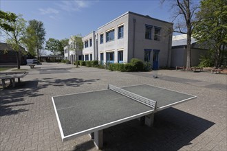 Empty square with table tennis table in front of a school, closed due to Corona pandemic