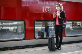 Woman with face mask, waiting for train