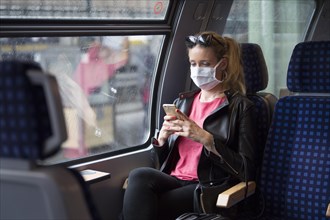 Woman with a face mask, sitting in Zug